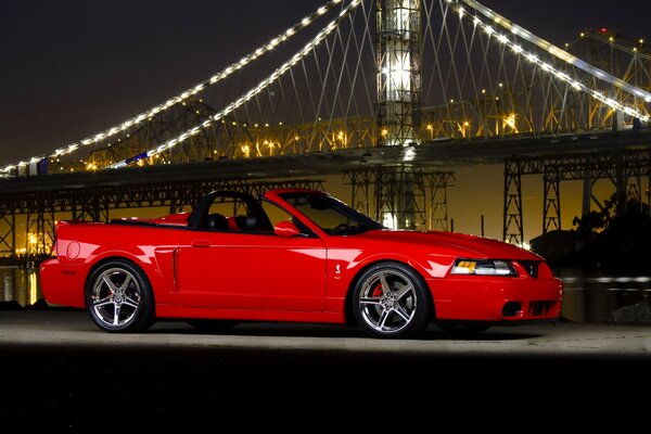 Red ford mustang at night in profile