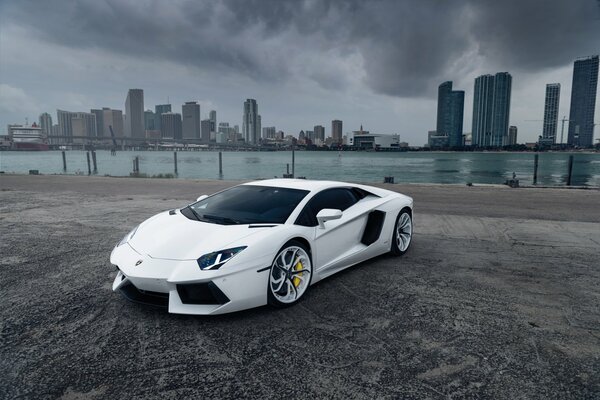 Lamborghini blanco en el fondo de la ciudad nublada