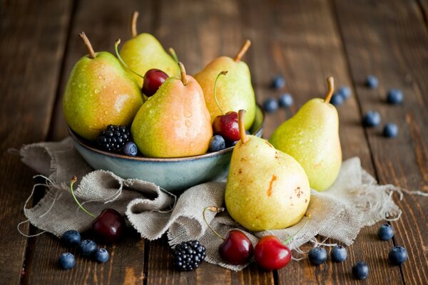 Mûres, myrtilles, poires et autres fruits dans une assiette