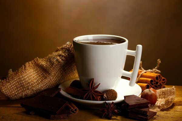 Drink on a saucer with cinnamon and sweets