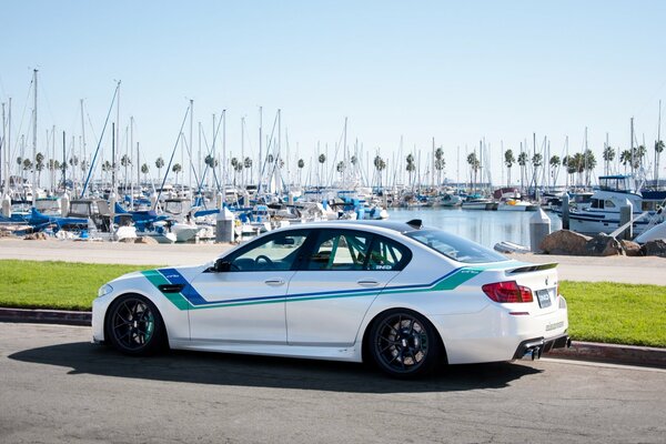 Voiture de sport bmw sur fond de quai avec yachts