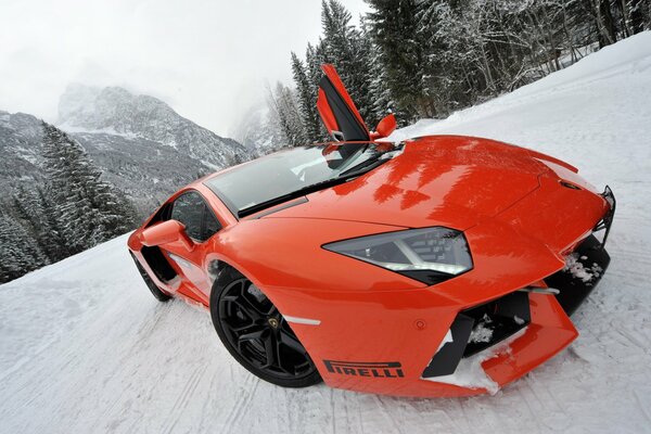 Voiture de sport corail lamborghini en hiver sur une route enneigée