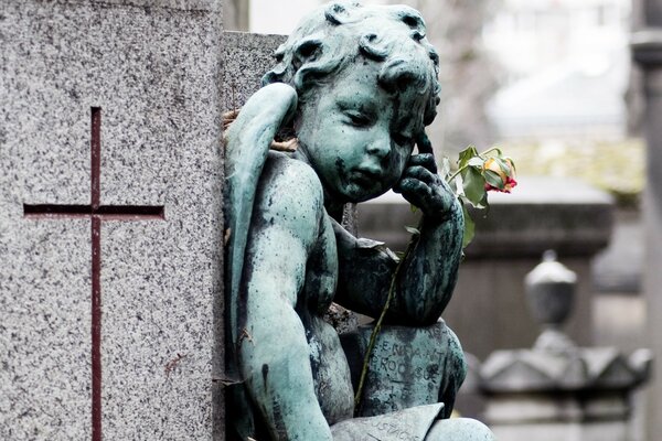 Sculpture of an angel with a flower on a gray background