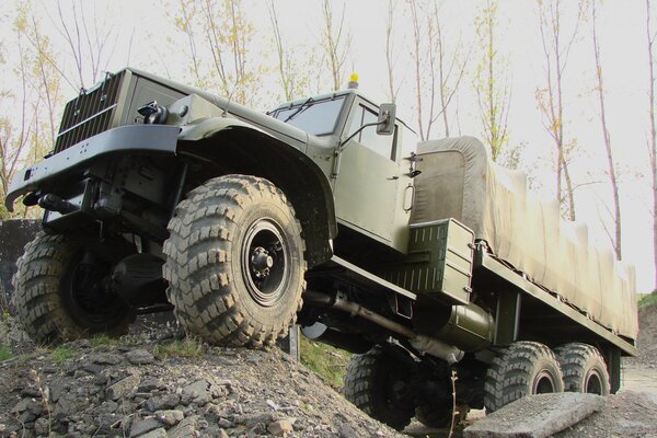 Camión militar conduce fuera de la carretera