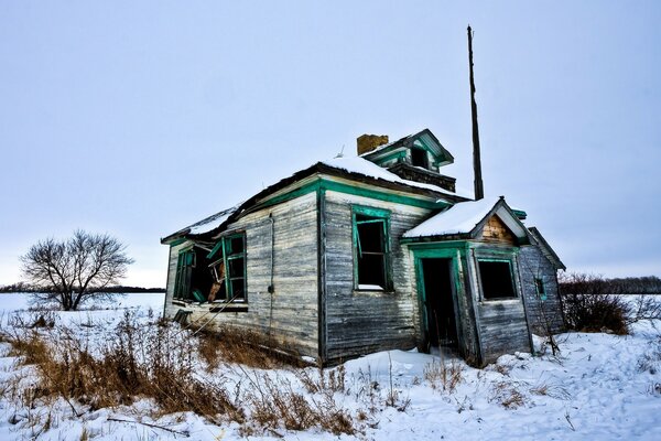 Casa destruida en un campo cubierto de nieve