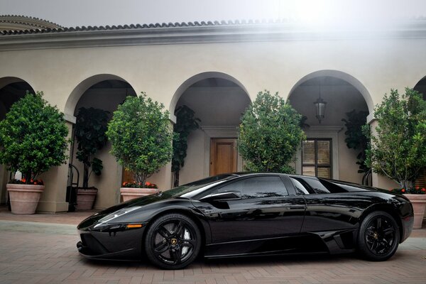 Lamborghini negro vista lateral cerca del edificio