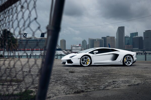 Blanc lamborghini vellano mc sur le fond de la ville sur le côté