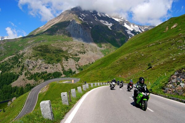 I motociclisti in montagna sulla strada guidano velocemente