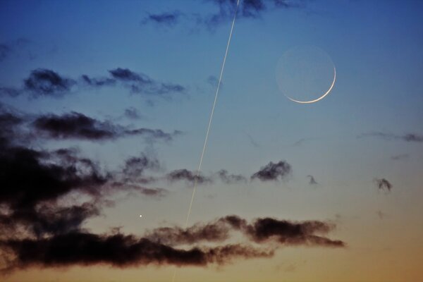 Nubes oscuras con rastro y Luna en el cielo