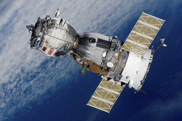 Satelita lecący w kosmosie, z napisem Sojuz