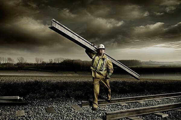 Travailleur avec un rail sur le chemin de fer