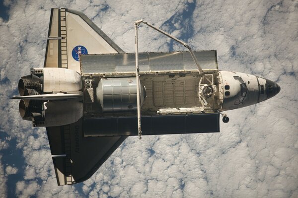 A shuttle flying high above the clouds