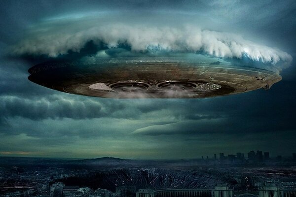 UFO tra le nuvole sopra la città della sera