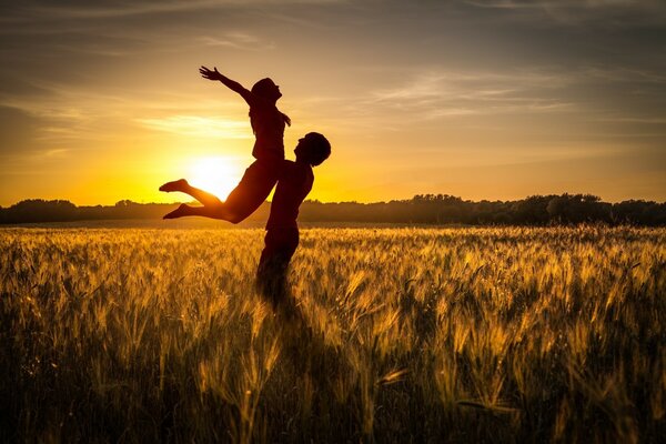 Pareja enamorada en medio de una puesta de sol en el campo