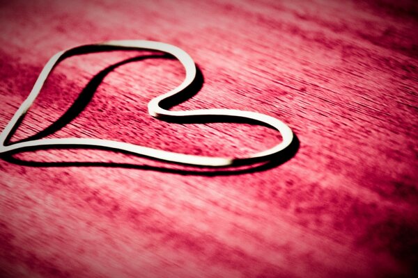 Metal heart on pink background