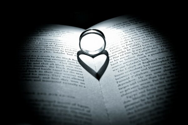 The ring between the pages of the books casts a shadow in the form of a verd