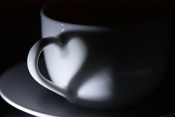 La poignée sur la tasse avec l ombre forment le coeur