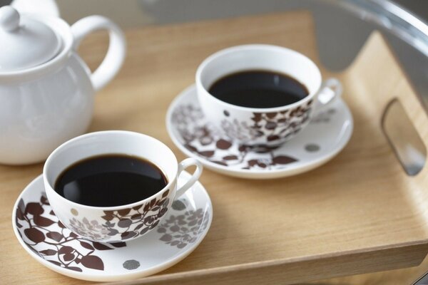 Deux tasses blanches en motif floral avec café