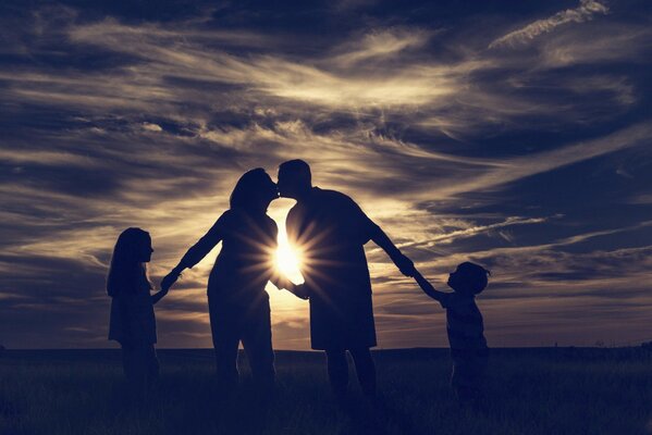 Familie im Hintergrund des Sonnenuntergangs