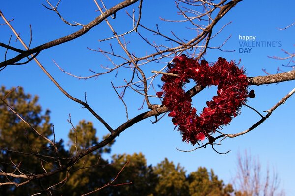 Ein großes Valentinsgrußherz hängt an einem Baum