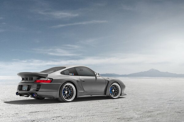 Srebrny Porsche na pustyni widok z boku