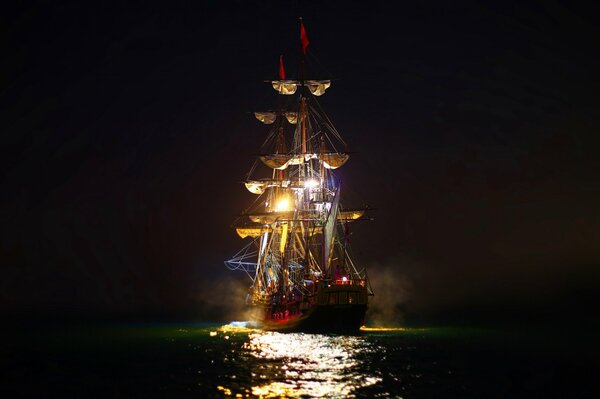 Night lights of a sailboat sailing on the sea