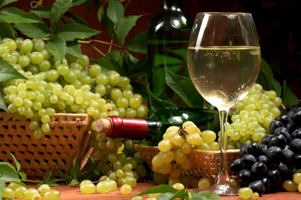 A glass of wine on the background of baskets with grapes