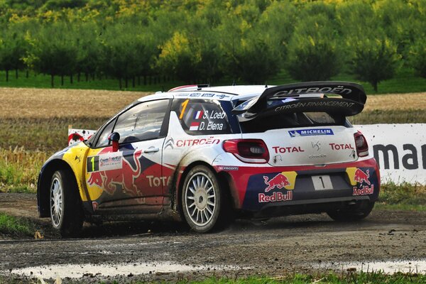 A Citroen sports car drives through the track in the mud