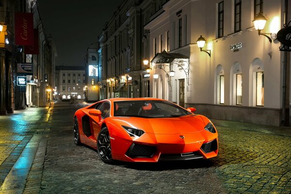 Lamborghini arancione nella città notturna