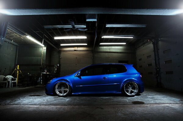 Niebieski Volkswagen z fajnym tuningiem w garażu