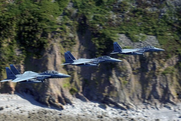 Tres combatientes militares sobre las montañas