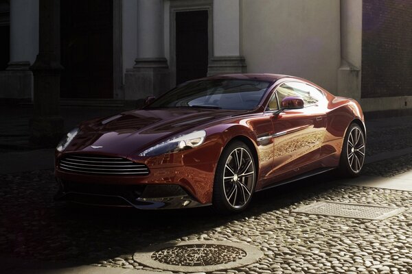 Coche rojo Aston Martin en un edificio clásico