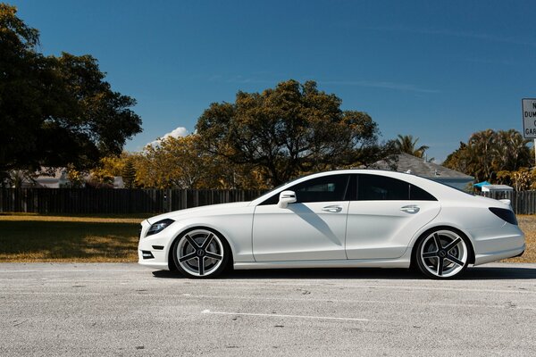 There is a beautiful, white car on the road