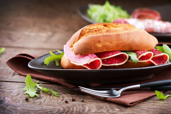 Panino con salsiccia affumicata cruda e insalata