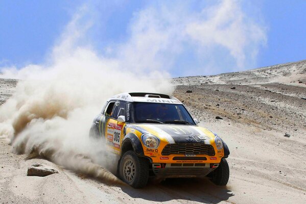 Mehrfarbiger Mini cooper, der in Sand und Staub steckt