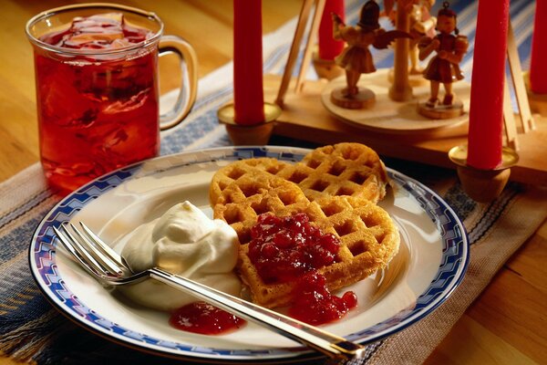 Tè per la colazione con cialde e marmellata su un piatto