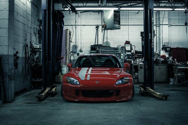 Red Honda under repair in the garage