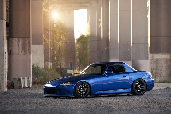 Ein blauer Honda. Schönes Foto mit der Sonne np Parken unter der Brücke