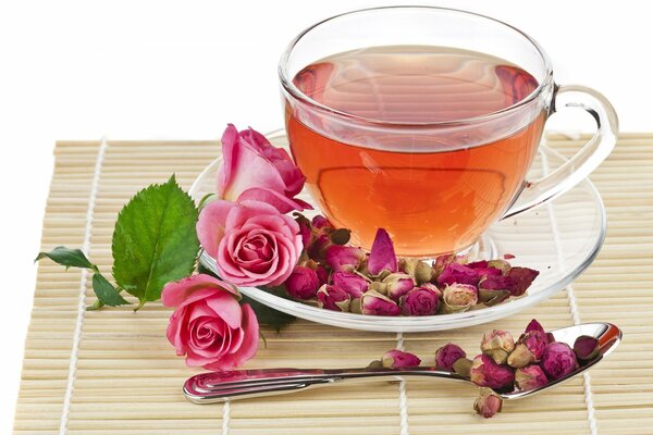 Té en una taza de vidrio sobre un fondo de rosas