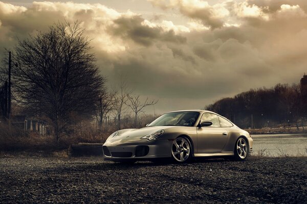 El coche gris de porsche en un fondo sombrío