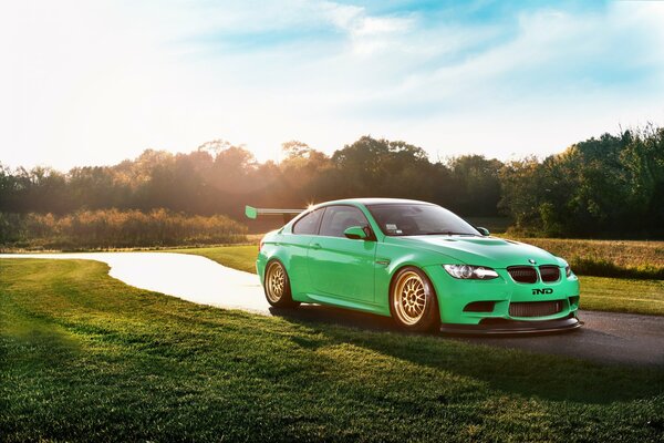 BMW verde in abbagliamento su strada soleggiata