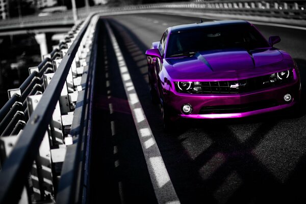 Purple Chevrolet camaro tuning on the bridge in motion