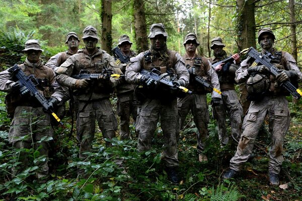Men in military uniforms with machine guns