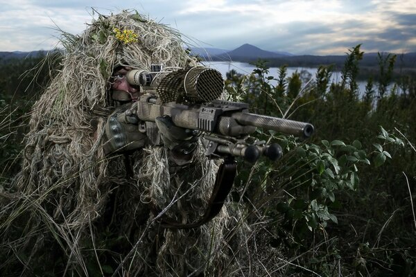 A man is hiding in a shelter with a machine gun