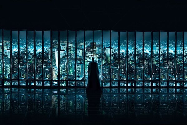 Batman blickt aus dem Fenster auf die Stadt