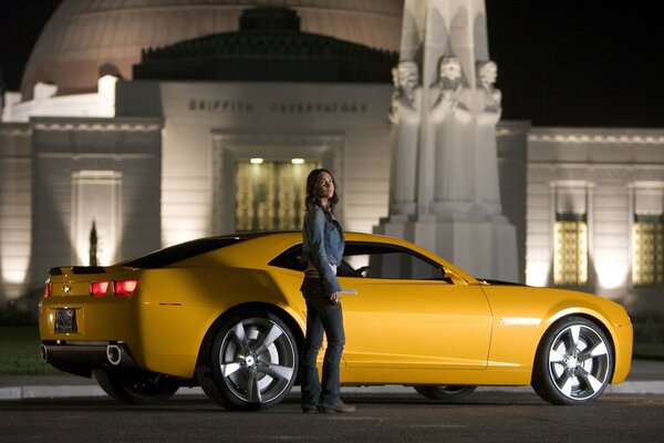 Megan Fox from the movie Transformers with a yellow car