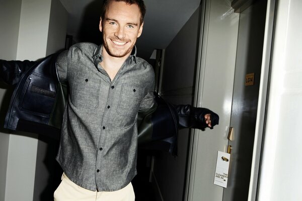 La risa de Michael Fassbender en una camisa gris