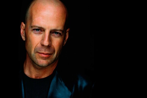 The face of actor Bruce Willis on a black background