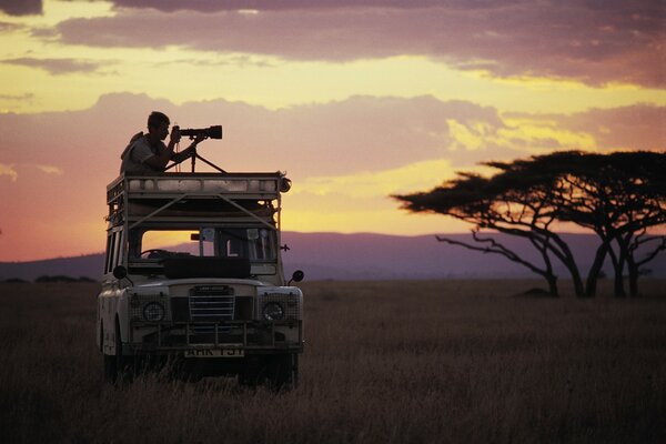 Un fotografo sul tetto di un auto in Africa cattura una cornice