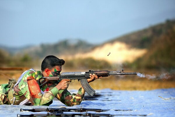 A soldier on a training exercise with a weapon lies